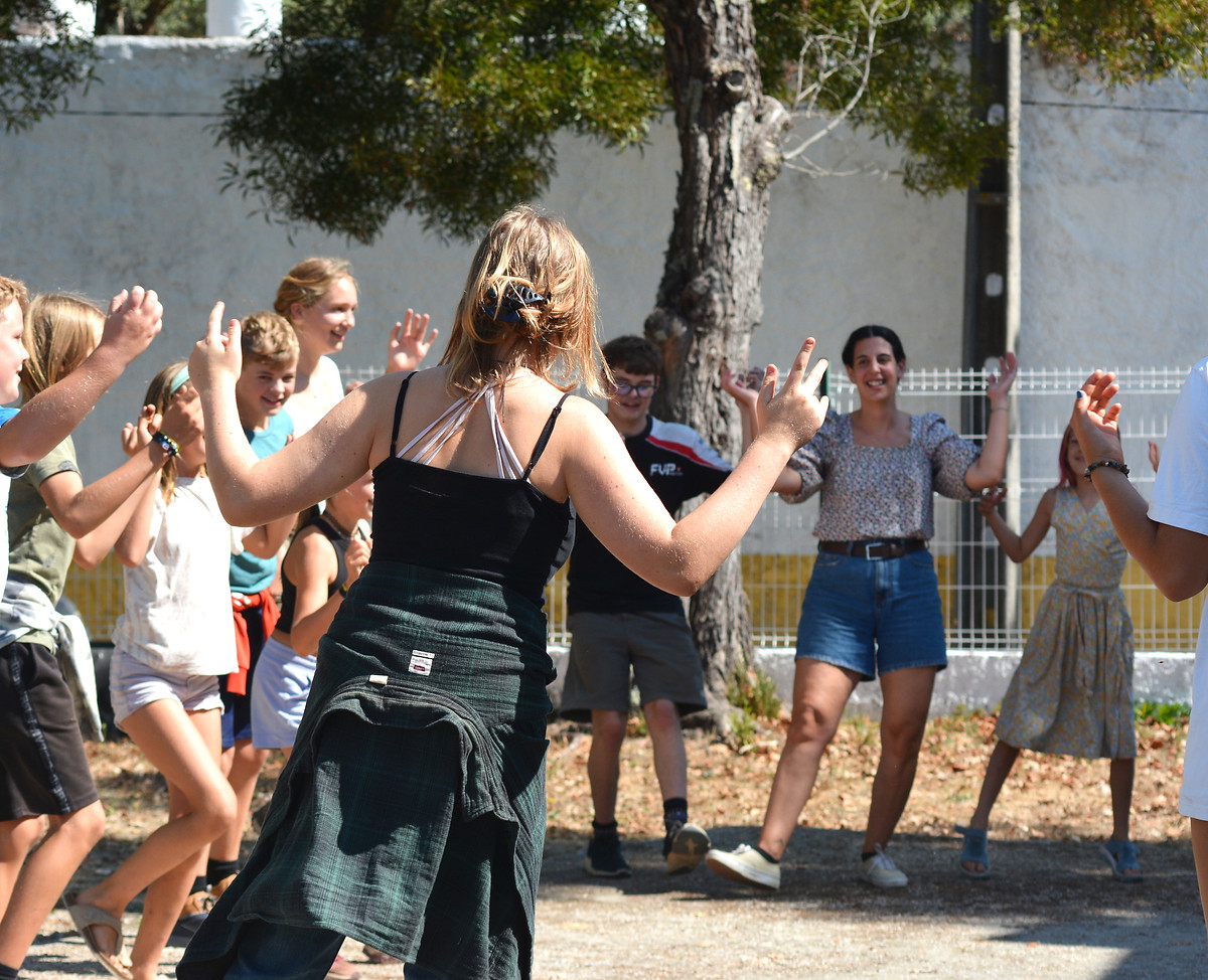 A group taking part in a movement activity beneath a tree at Waterfall Valley