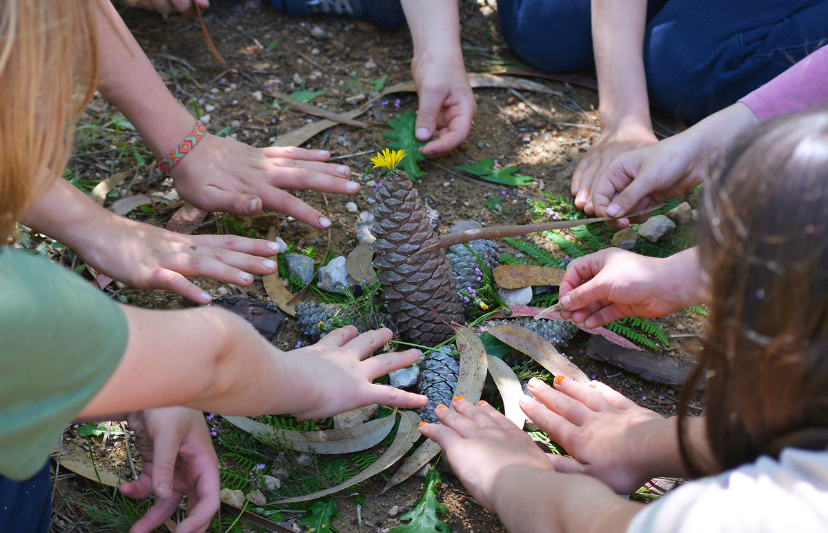 Children arranging natural materials outdoors at Waterfall Valley