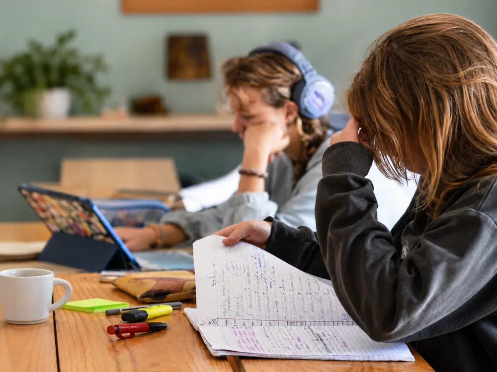 Two young people studying with notebooks and a tablet at Waterfall Valley